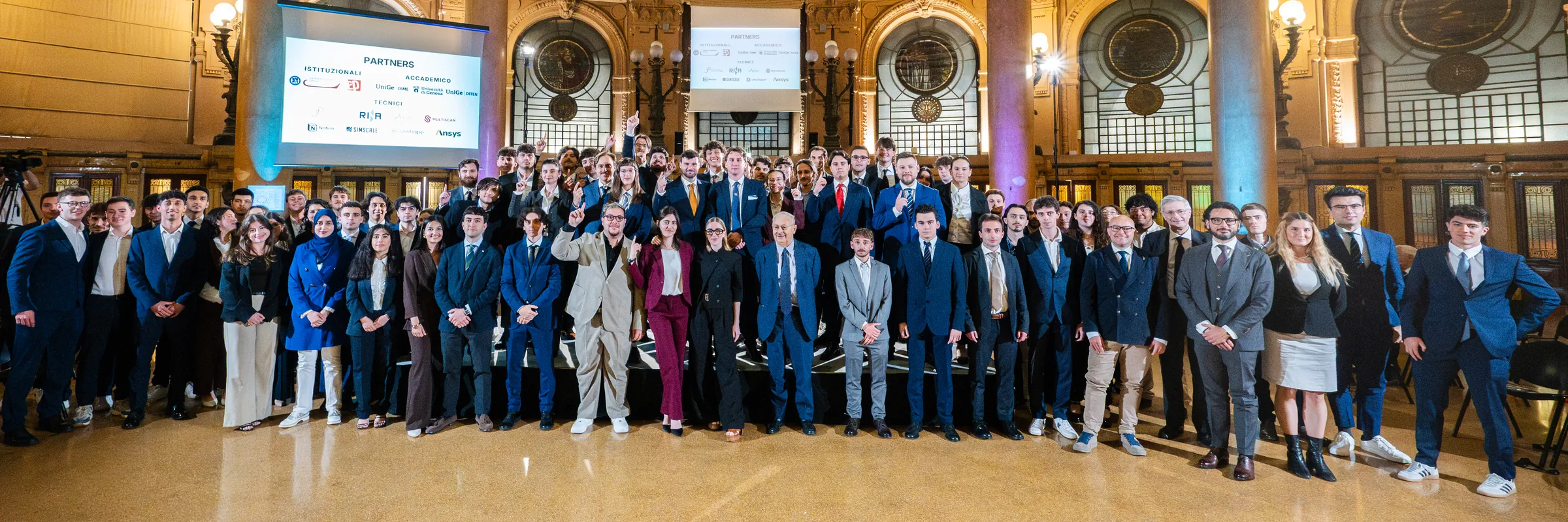 Un centinaio di persone in posa nella sala di Palazzo della Borsa, a Genova