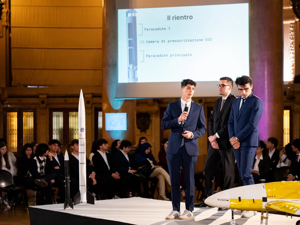 Andrea Beverini e la squadra dei razzi spiegano sul palco come il razzo torna a terra con i paracadute