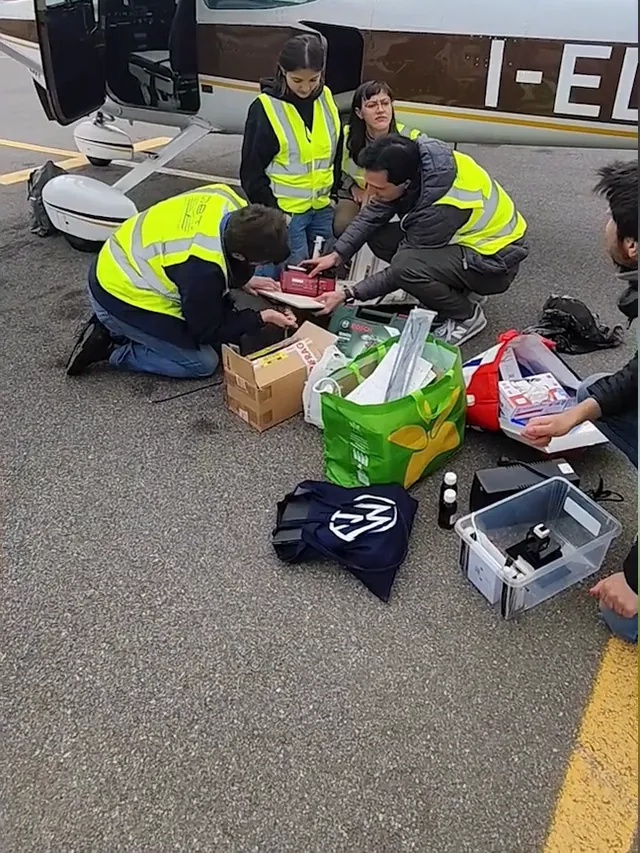 La squadra in giubbotto giallo prepara l’esperimento sulla pista, accanto all’aereo